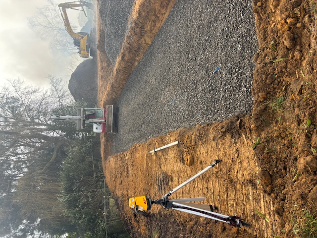 Professional drainage installation with survey equipment